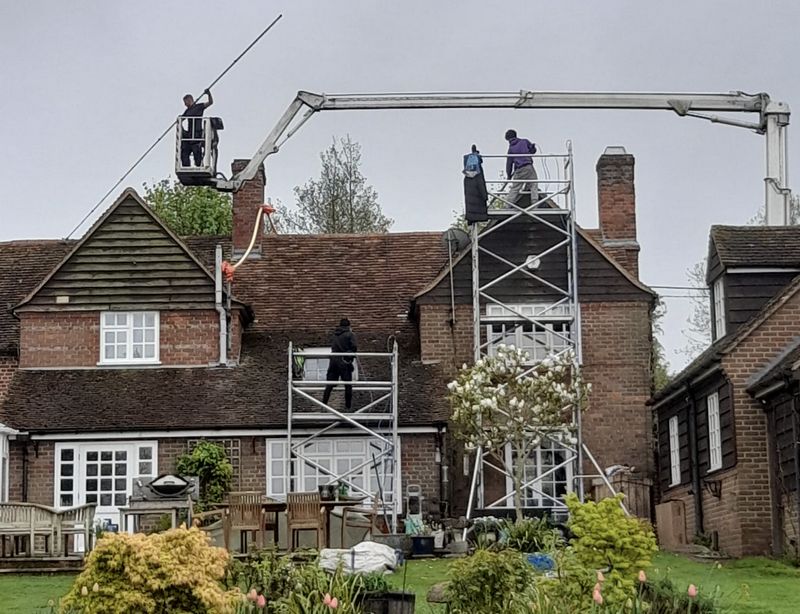 The Moss Cleaners using cherry picker and scaffolding to clean roof safely and professionally in Four Marks, Hampshire